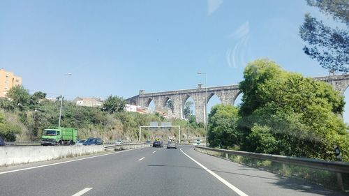 Road amidst trees against clear sky