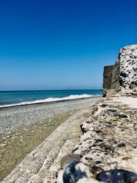 Scenic view of beach against clear blue sky