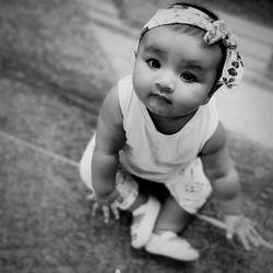 Portrait of cute baby girl sitting on floor