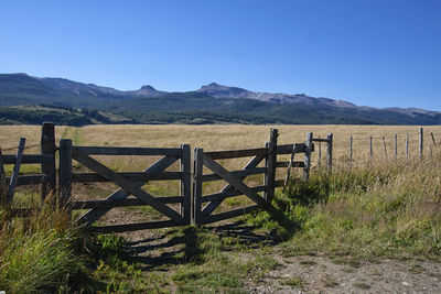 Wooden fence on field against sky