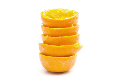 Close-up of stacked orange peels against white background