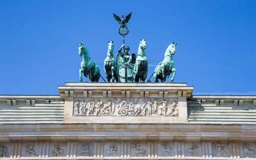 Low angle view of statue against blue sky