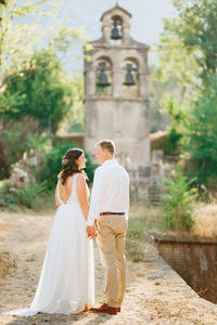 Rear view of couple holding hands