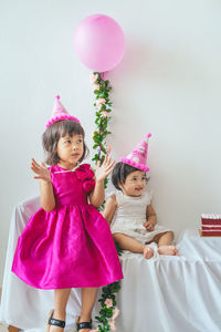 Portrait of happy girl with pink balloons