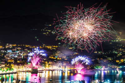 Firework display over river at night