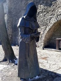 Statue against stone wall