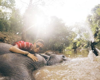 Man hugging elephant in water