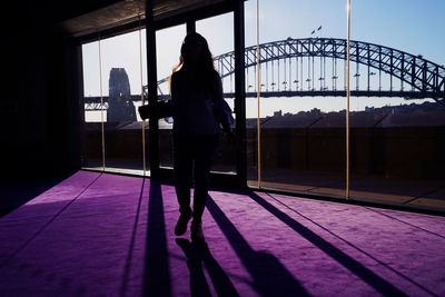 Rear view of women standing on bridge