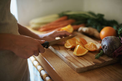 Cropped hands of man preparing food on cutting board