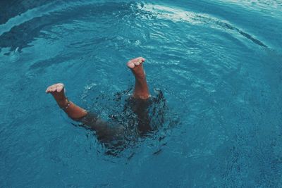 Low section of person swimming in pool