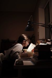 Rear view of woman using digital tablet while sitting at home
