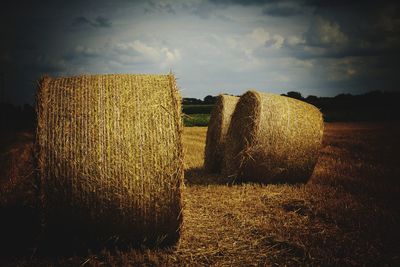 Hay bales on field against sky