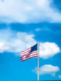 Low angle view of flag against blue sky