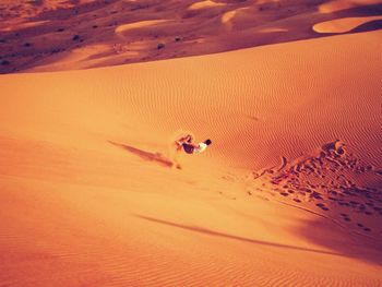 High angle view of man sandboarding at desert