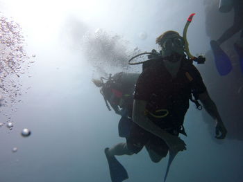 Low angle view of scuba divers swimming in sea