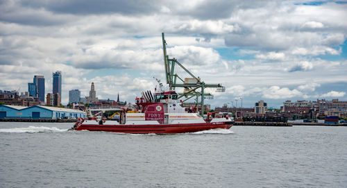 Ship in sea against cloudy sky