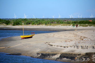 People on beach by sea against sky