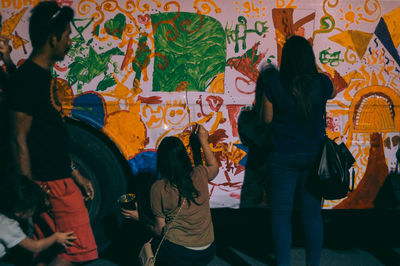 Rear view of two people standing at music concert
