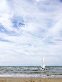 Sailboat sailing on sea against sky