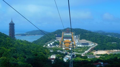 Overhead cable car over mountains against sky