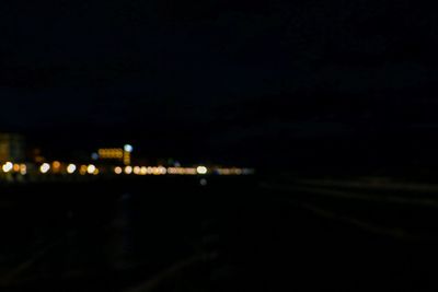 Illuminated bridge over city against sky at night
