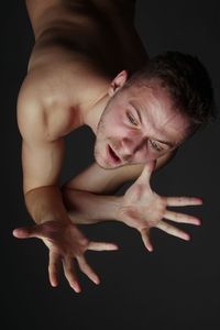 Portrait of young man against black background