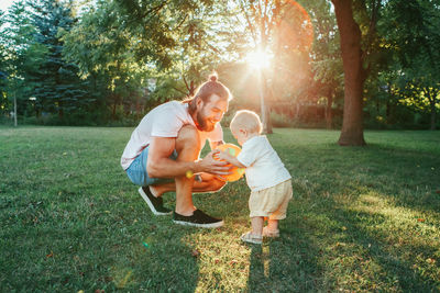 Father playing with son with ball at park