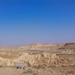 Scenic view of desert against clear blue sky