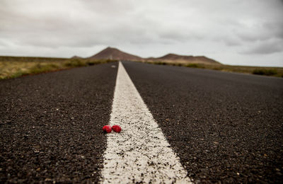 Surface level of road amidst land against sky