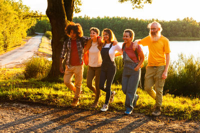 Rear view of friends walking on field