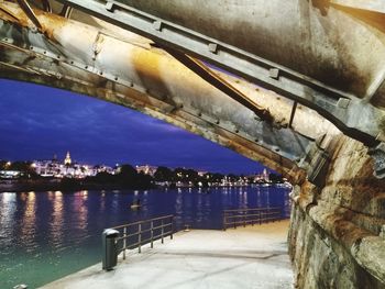 Bridge over river in city against sky