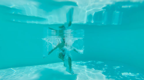 Low section of people swimming in pool