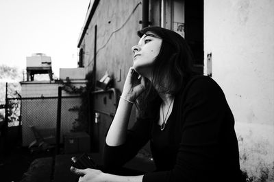 Portrait of woman standing by railing