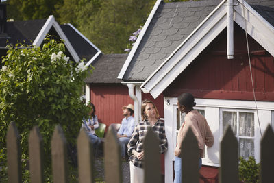 Women talking in front of wooden house