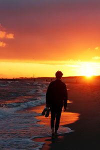 Rear view of silhouette of man at sunset