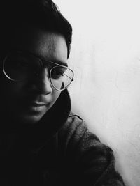 Portrait of young man wearing sunglasses against wall