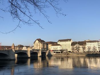 Bridge over river in city against clear sky