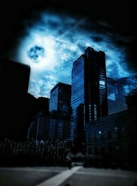 Buildings in city against cloudy sky