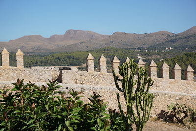 Low angle view of fort and mountains against sky