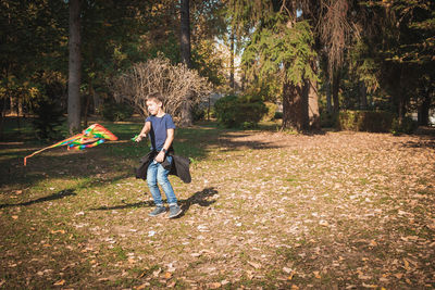 Full length of boy playing kite in park