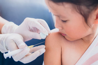 Doctor injecting girl at clinic