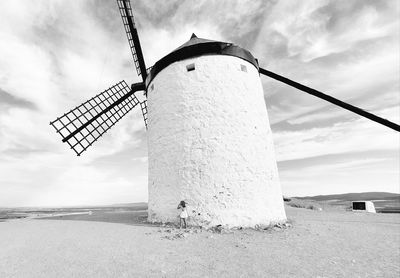 Traditional windmill on field against sky