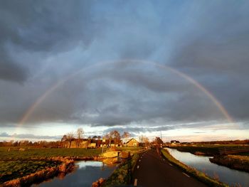 Scenic view of rainbow over road against sky