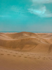 A warm summer day at sand dunes overlooking the blue horizon in the canary islands, spain.