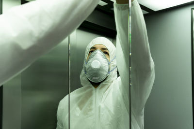 Coronavirus. worker disinfecting hospital elevator to avoid contagion.