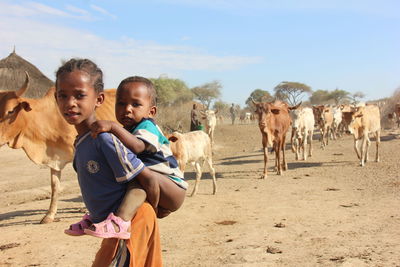 Portrait of children on land against sky