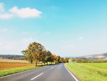 Empty road passing through field