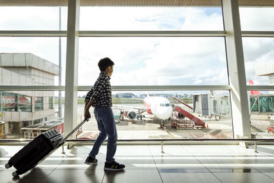 Man standing by window at airport