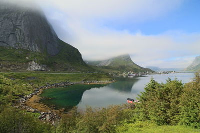 Scenic view of lake by mountains against sky