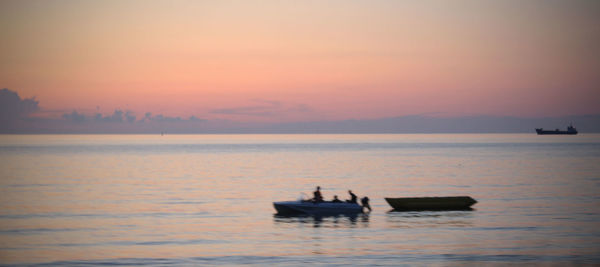 Silhouette boat in sea against sky during sunset
